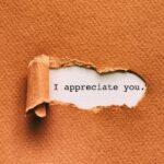 Brown textured paper with a torn opening revealing the text "I appreciate you." on a white background.