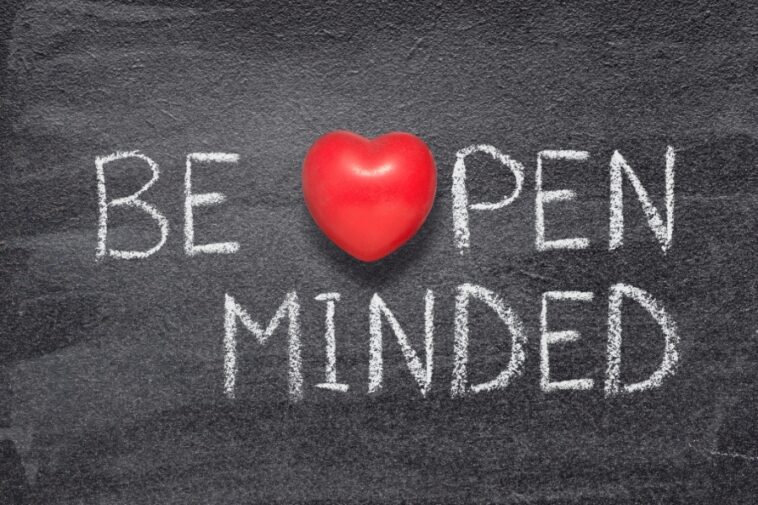 Chalkboard with the words "BE OPEN MINDED" written in white chalk, with a red heart shape replacing the word "HEART".