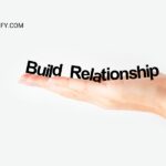 A hand holds the words "Build Relationship" against a white background.