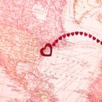 Vintage-style map showing North America and Europe, with a line of small red hearts connecting New York and the British Isles, each marked with a larger red heart.