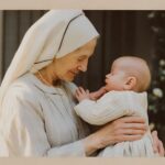 An older woman in a white head covering and dress holds a baby, both facing each other.